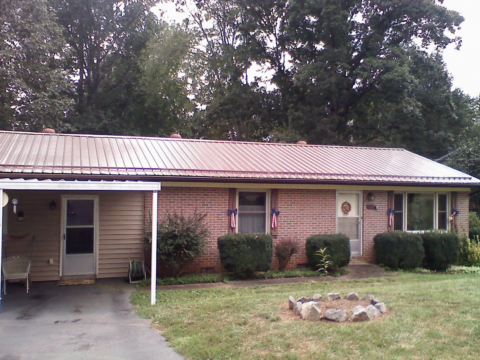 Bronze metal roof and carport on a brick ranch home — Roof Repair work by our crew in Grand Coteau